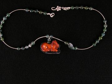 Chinese boxwood horse lying on green stone on necklace of moss agate
