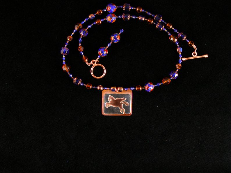 Sterling cut out Pegasus on heat patinaed copper