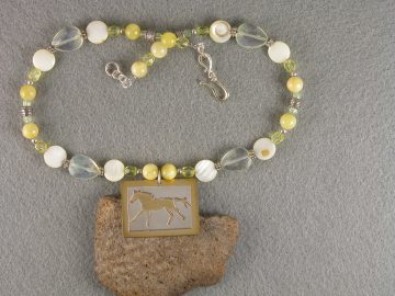 Sterling cut out galloping horse on brass