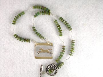 Sterling cut out galloping horse on brass on necklace of turquoise
